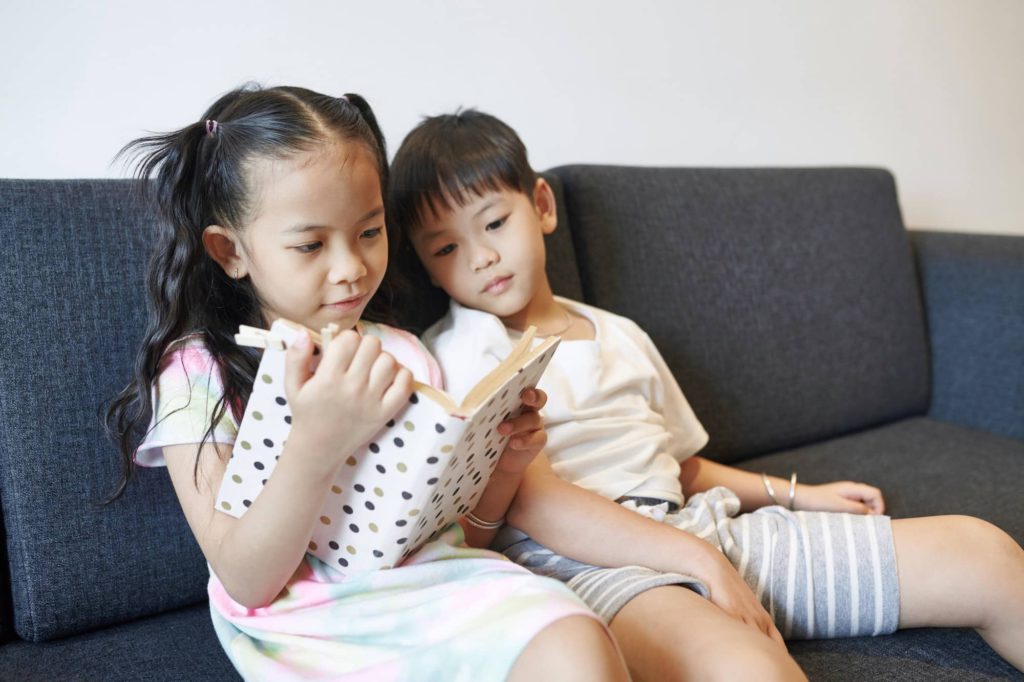 Siblings reading book