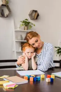 mother embracing daughter sad about math homework